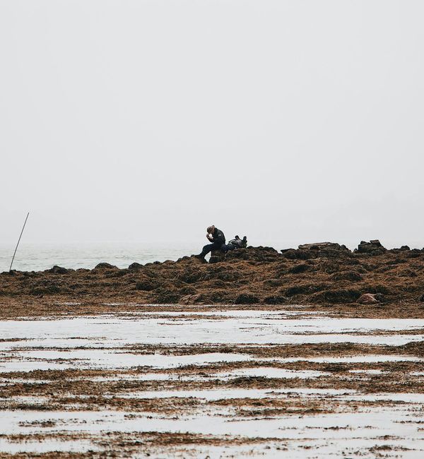 Person meditating peacefully outdoors with a serene landscape background.